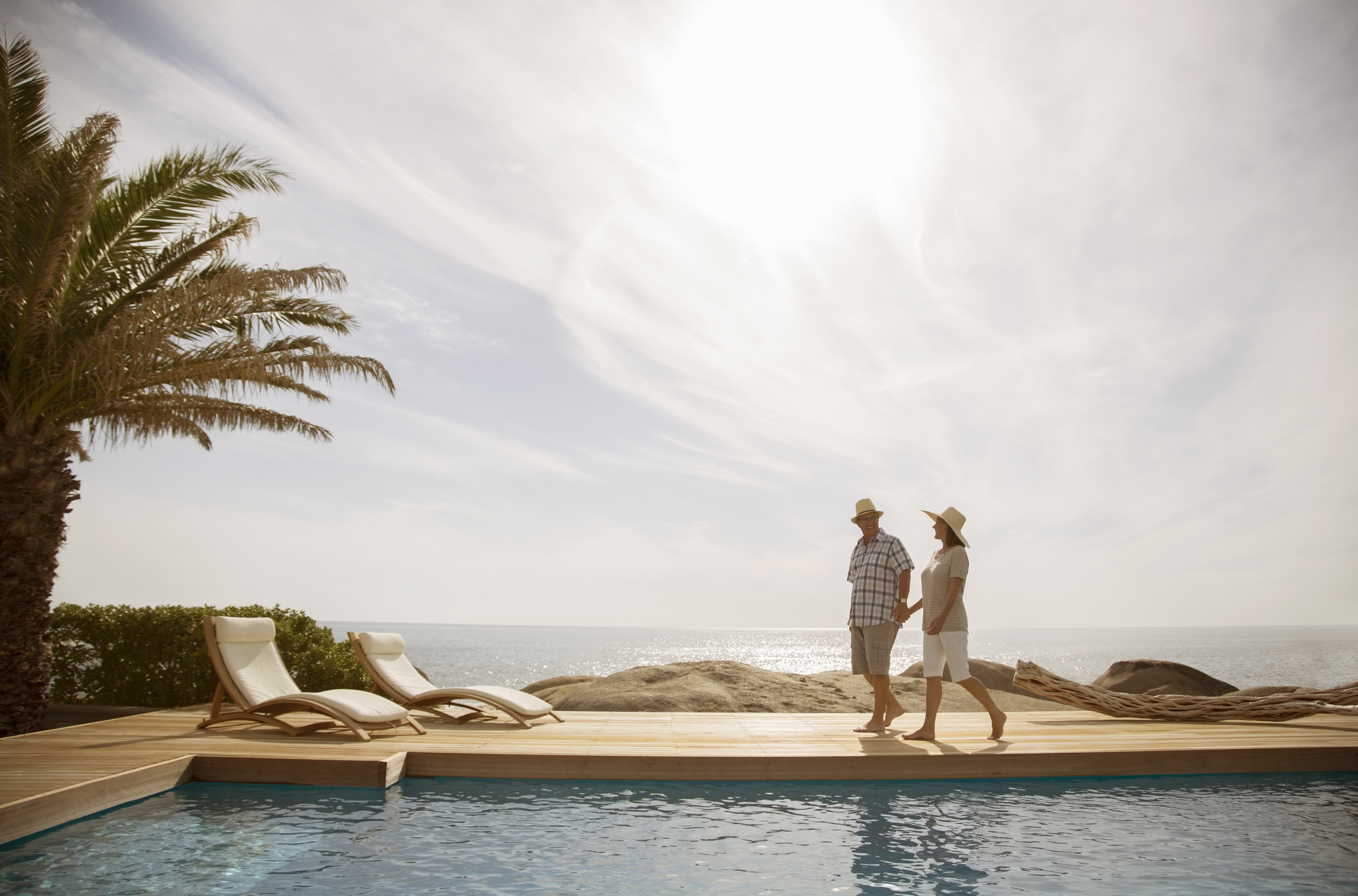 Couple relaxing by a modern infinity pool